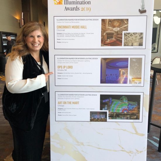 Michelle Eble-Hankins stands beside the display board for JP Lord Elementary's IES Special Citation Award