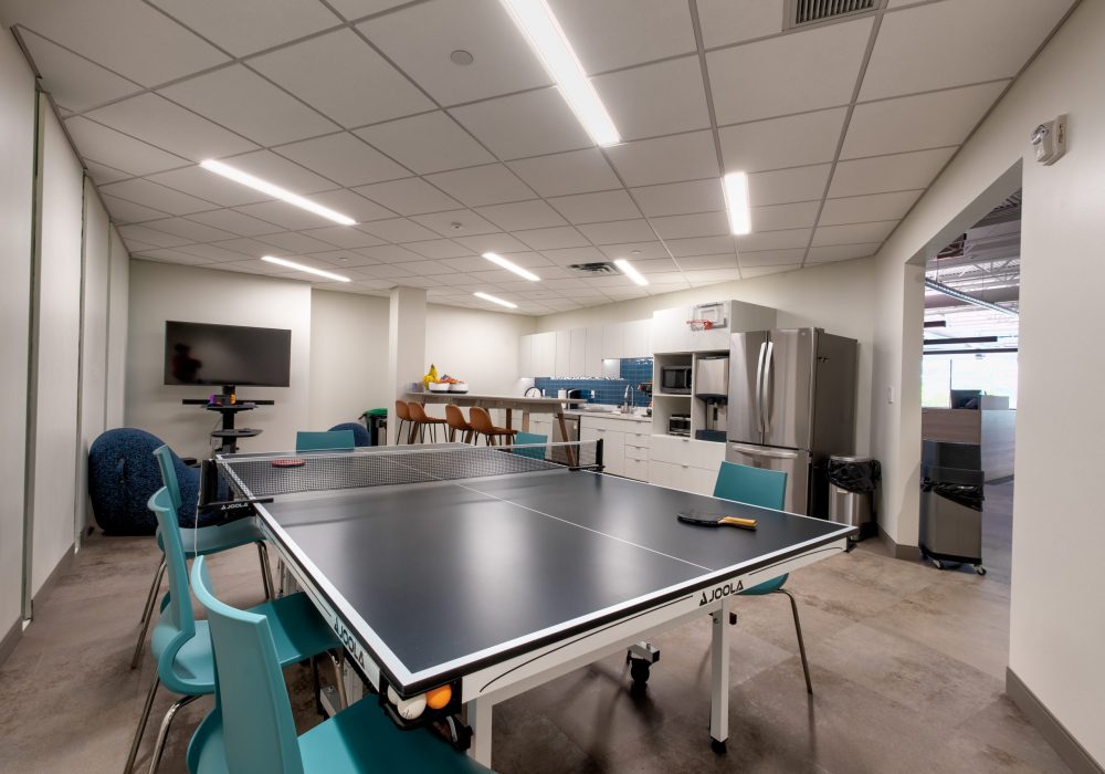 Interior shot of Alvine Engineering's Oklahoma City office's kitchenette and area with a ping pong table and TV